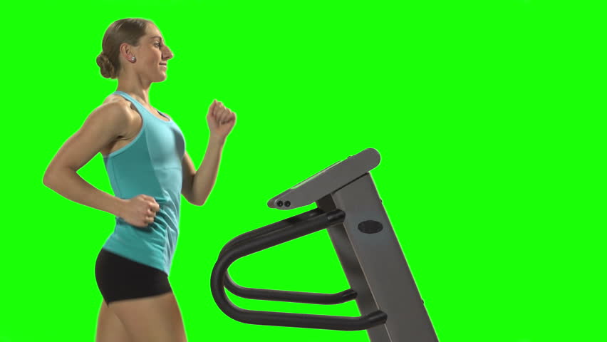 Young woman running on the treadmill in front of green screen, profile