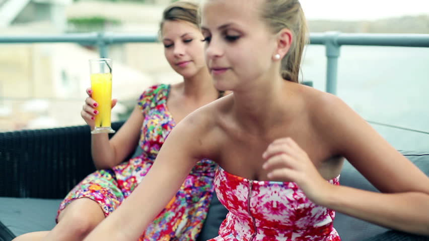 Female friends drinking beverages in restaurant by the sea, steadicam
