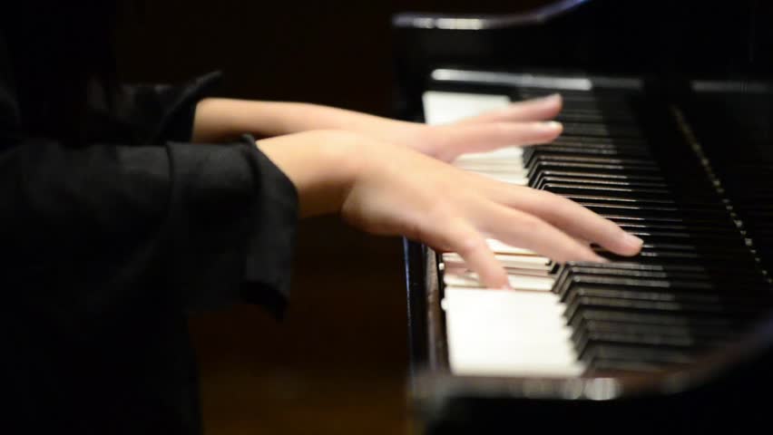 Kid playing nice song on a grand piano during recital (close up) High Definition HD 1080P