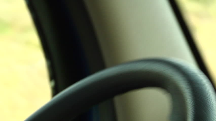 Hands turning steering wheel