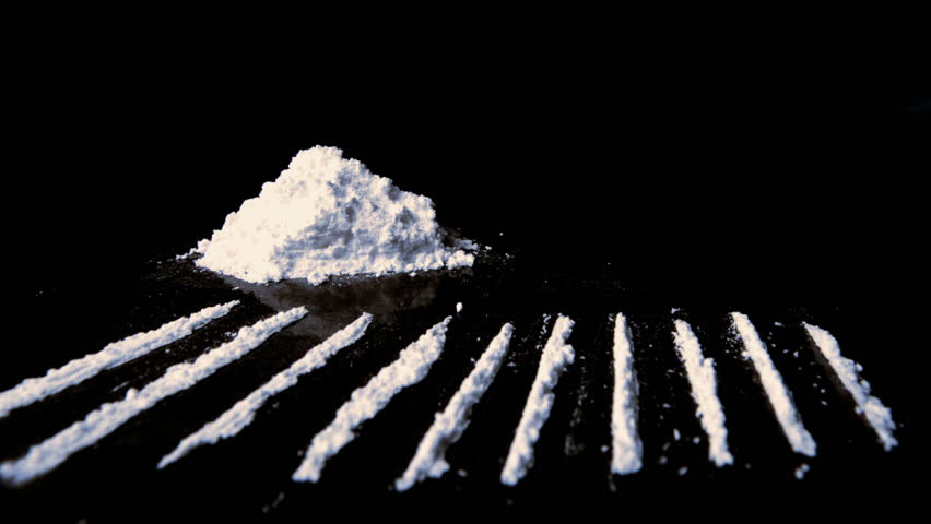 Rolled up dollar falling on drugs with lines racked up in slow motion