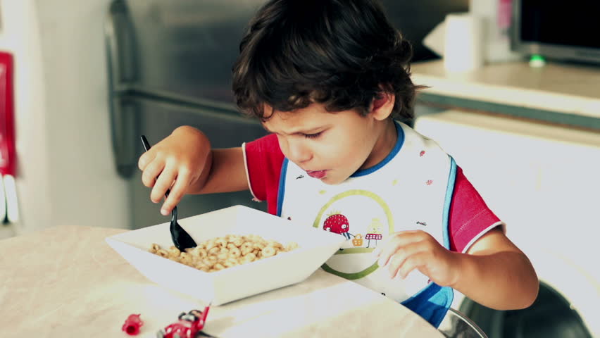 Little boy eating cornflakes with milk, slow motion shot at 240fps

