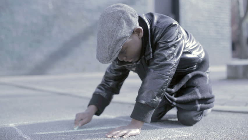 African American Black kid with hat drawing a number in chalk on the floor