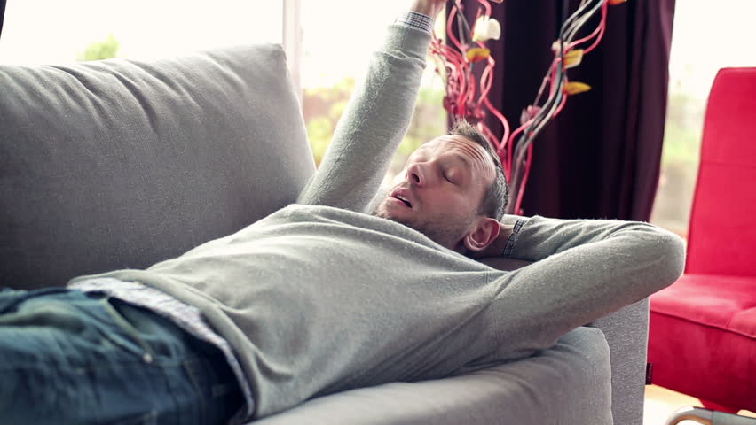 Young man taking nap on sofa at home
