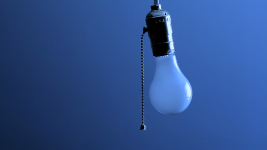 Woman's hand comes into frame, pulls chain and turns off hanging light bulb, shot in HD video