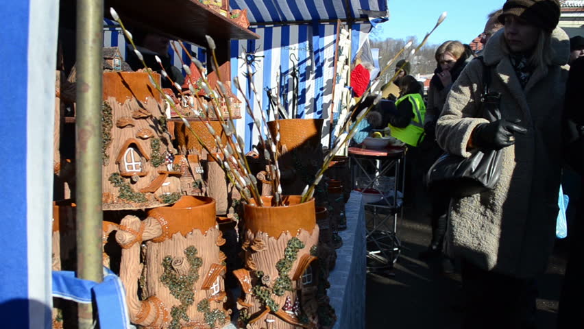 VILNIUS, LITHUANIA - MARCH 02: Woman look at pussy-willow catkin in various handmade crockery clay vases and pots sell in city street market fair on March 02, 2012 in Vilnius.