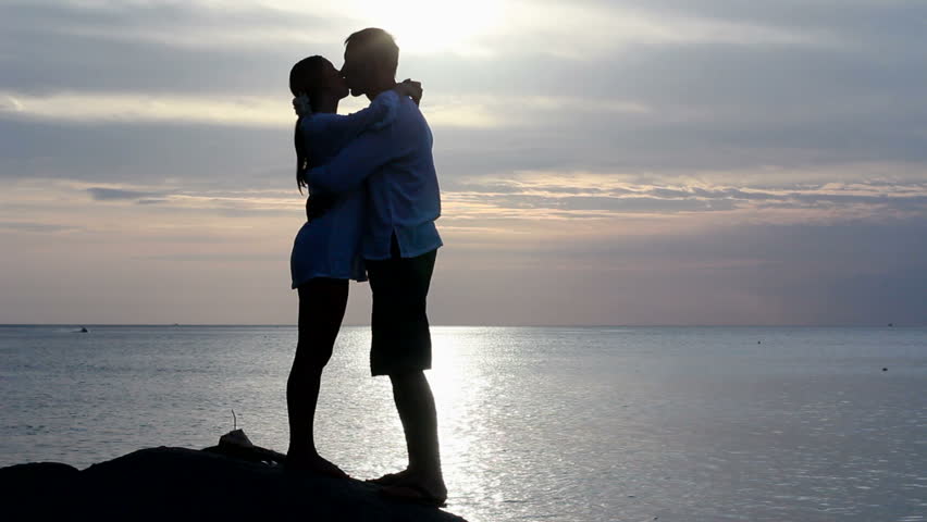 Couple silhouette at the beach. Sunset light.