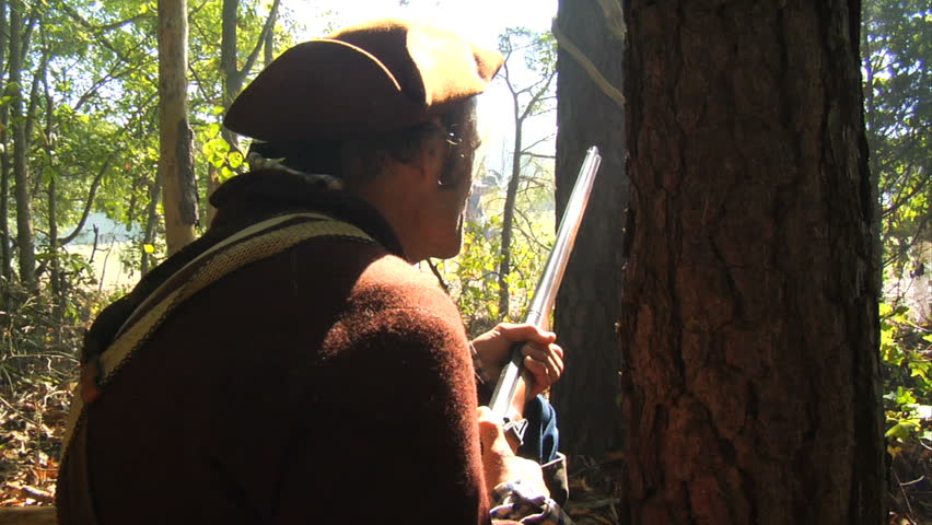 VIRGINIA - OCTOBER 2009 - large-scale, epic American Revolutionary War anniversary reenactment -- in the middle of battle.  Continental Army Minuteman / Militia in the woods, loads and fires.