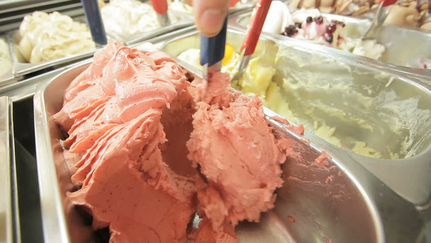 cu on a spoon mixing strawberry flavoured ice cream  in a silvercontainer