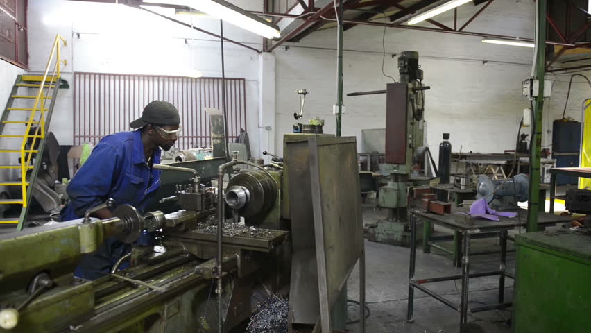 An industrial service repairmen labouring in workshop, selective focus, working on industry machine 