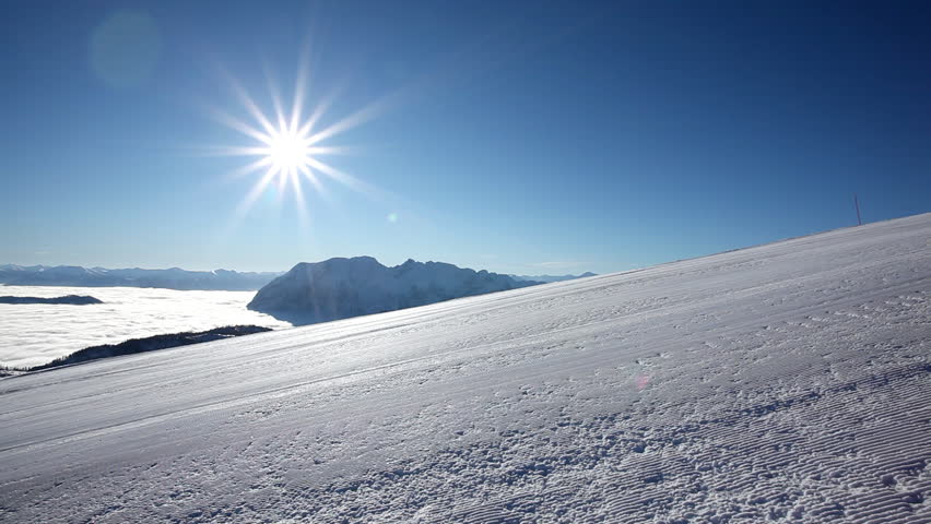 woman carving on empty piste at blue sky and sunshine