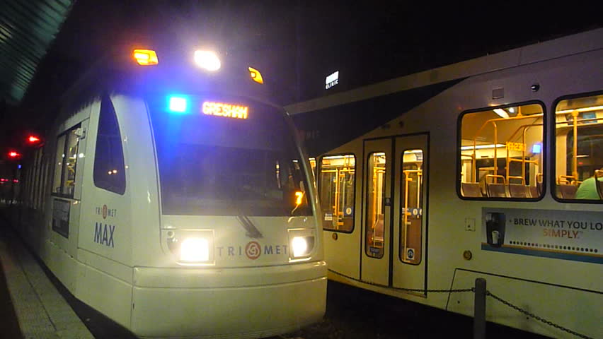 PORTLAND, OREGON - CIRCA 2012: Night exterior with metro trains traveling on rail, stop and go.