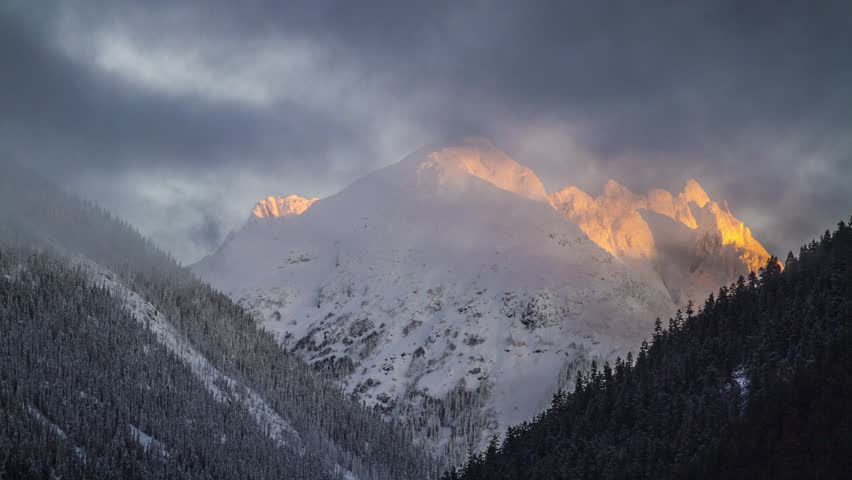 Time Lapse of cloudy morning by a snow mountain with Sun Light in the morning. Photo Sequence shot in RAW and Post-Production in After Effects.