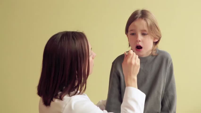Female Pediatrician taking temperature of a sick male child. 