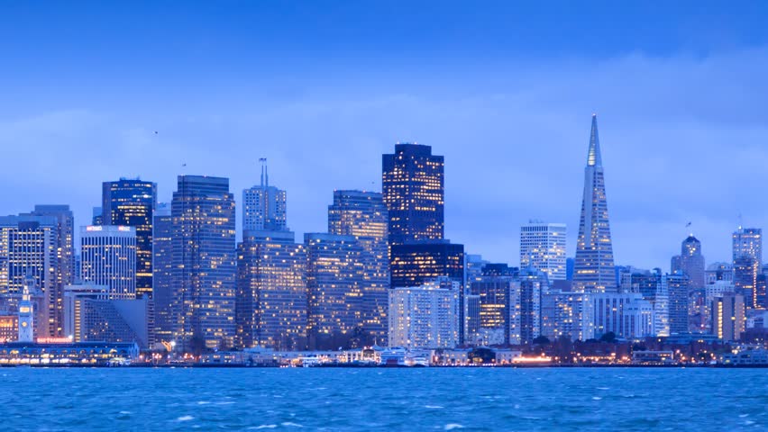 San Francisco skyline from twilight to night. View from Treasure Island. Zoom in on downtown. Timelapse.