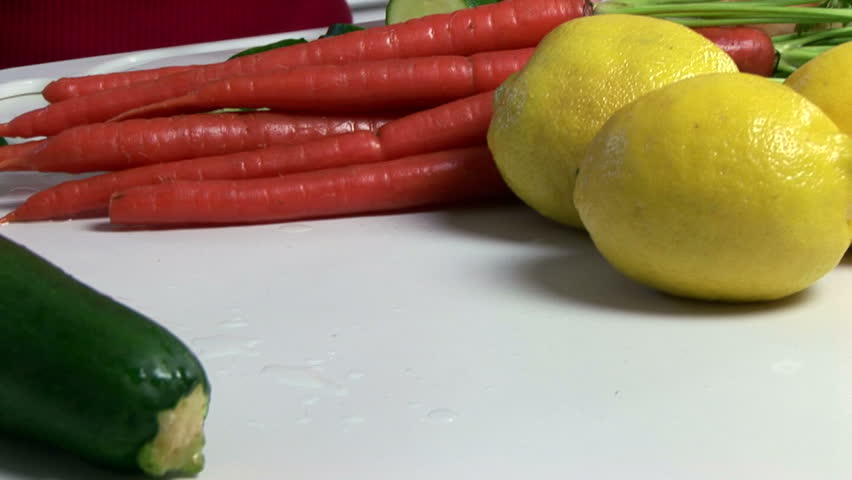 A woman slicing zucchini as part of the ingredients of a hearty vegetable soup.