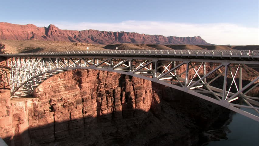 Navajo Bridge on the Colorado River near Page Arizona. Pan. Upstream from the Grand Canyon. Wide steel arch spanning steep canyon walls at Marble Canyon near LeeÃÂ¢??s Ferry crossing. 