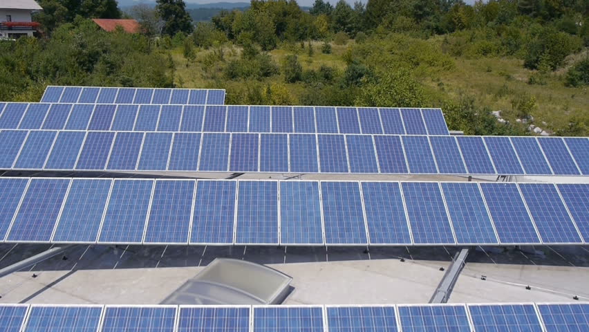 Panorama slide shot from helicopter representing an industrial part of a small town with roofs covered with solar power stations