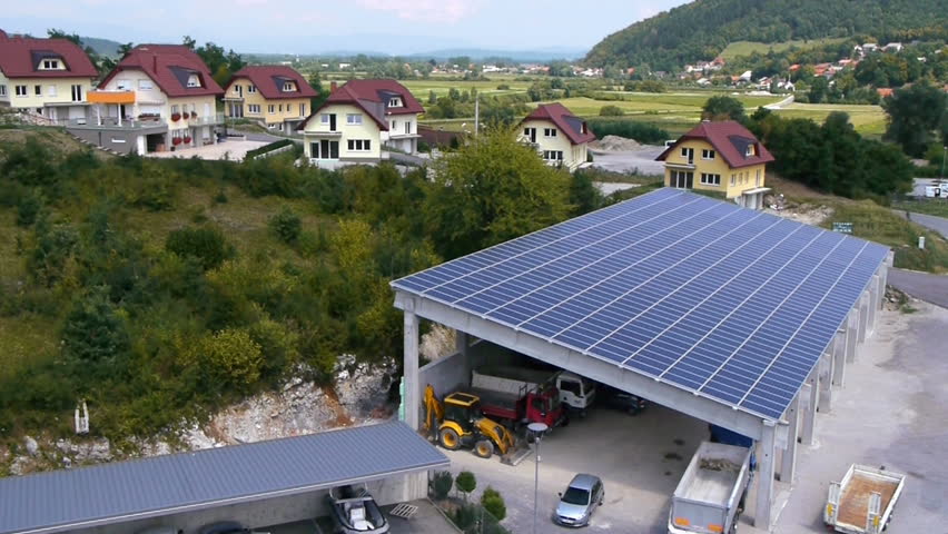 Panorama slide shot from helicopter representing an industrial part of a small town with roofs covered with solar power stations