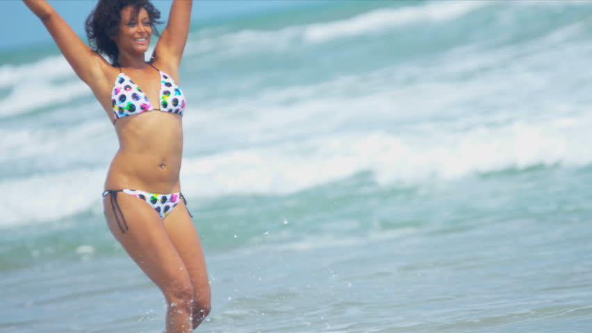 Pretty girl in bikini reveling being alone in ocean by beach vacation resort shot on RED EPIC