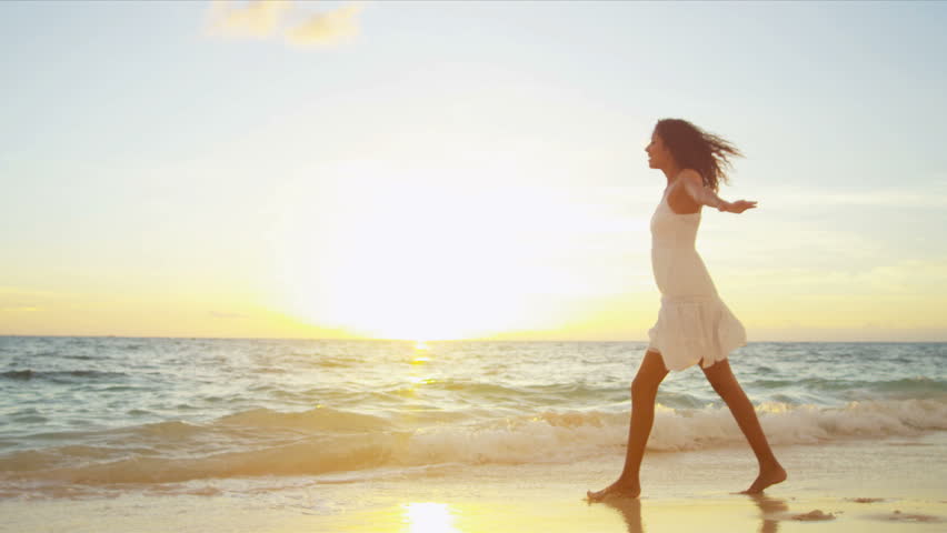 Pretty girl in sundress reveling being alone by ocean at sunset on beach vacation shot on RED EPIC
