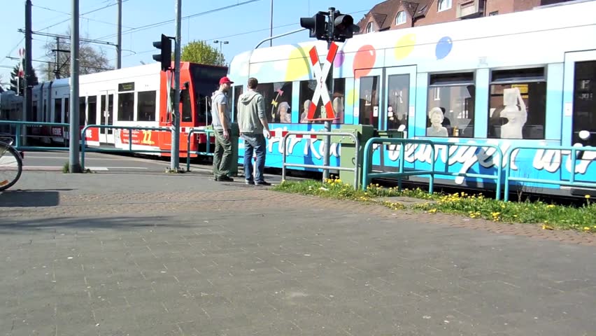 Cologne / Germany - circa april 2013 - Tram ( Line 7 ) runs through a crossing with barriers on the railway line between Cologne and Zuendorf.