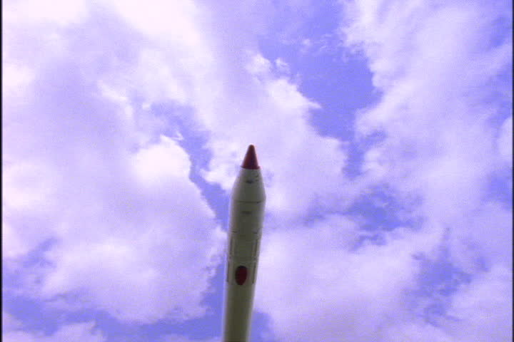 JOHNSON SPACE CENTER, HOUSTON, TEXAS - APRIL 28, 1999: Tilt down from blue sky filled with clouds to retired Saturn rocket.