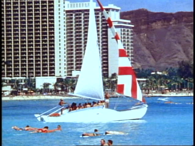 Waikiki, sailboat sailing out to sea past Diamond Head, medium shot