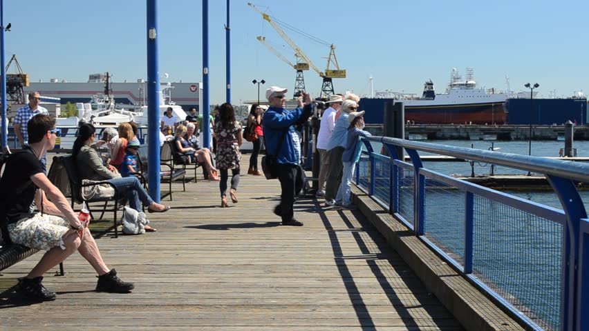 NORTH VANCOUVER, CANADA - MAY 5, 2013: Tourists and locals enjoy the sunshine on Lonsdale Quay. An early heatwave has broken records in southwest British Columbia this spring.