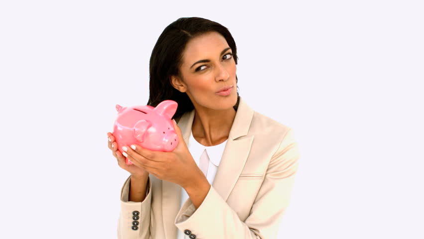 Businesswoman shaking piggy bank on white background in slow motion