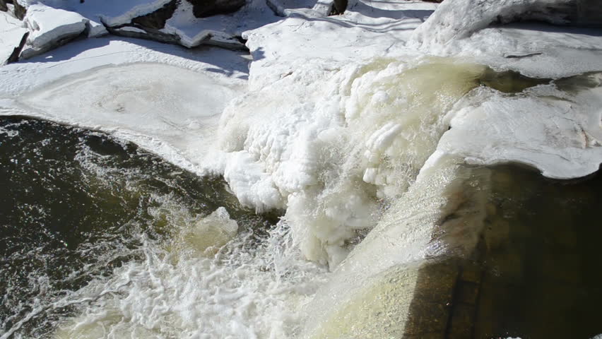 closeup of river cascade waterfall corner edge water fall down and splash bubble. beautifully frozen ice and icicles.