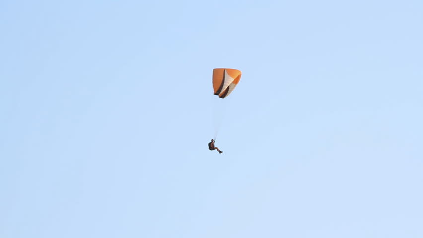 Paragliding over the mountains against clear blue sky