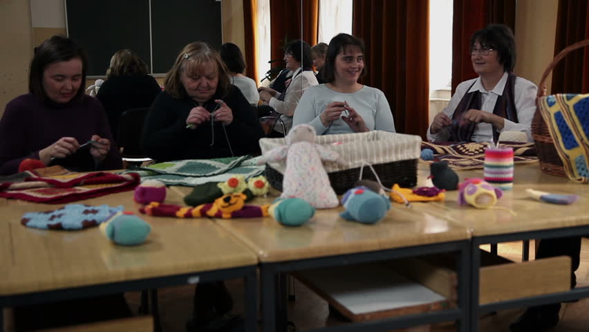 Old women knitting and old man watching