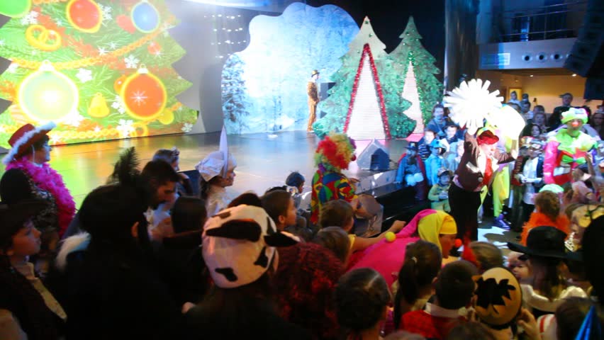 MOSCOW - JAN 04: ( rotating camera) People in front of stage with two clowns at Forum hall Moscow New Years masquerade of Moscow families, on Jan 04, 2012 in Moscow, Russia.
