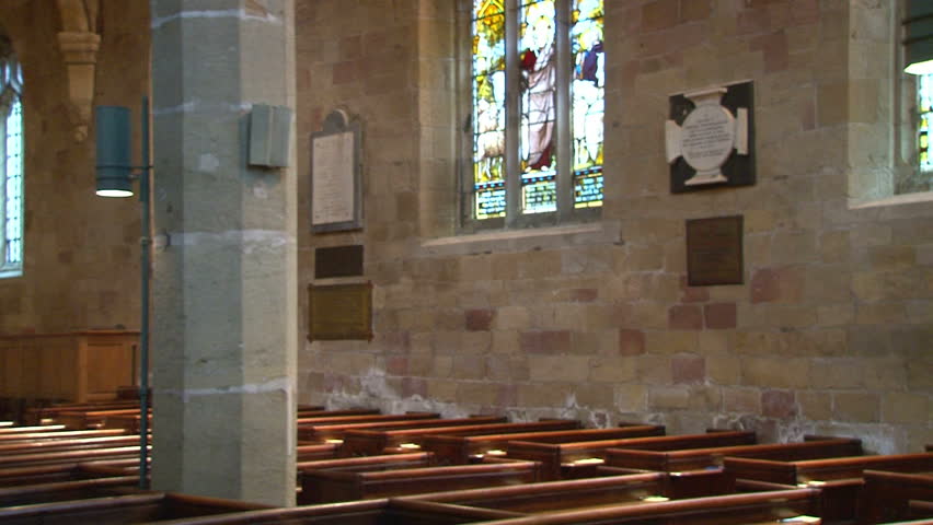 Nave of a church with rows of pews.