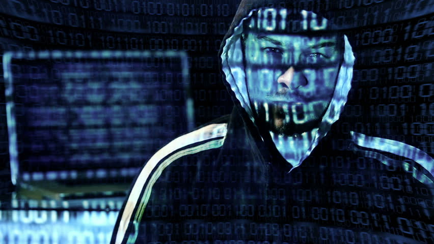 Hacker looking at the camera with laptop, binary codes projections and animation in background.
