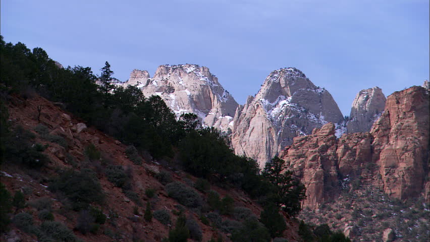 Zoom put, pan across valley to cliffs
