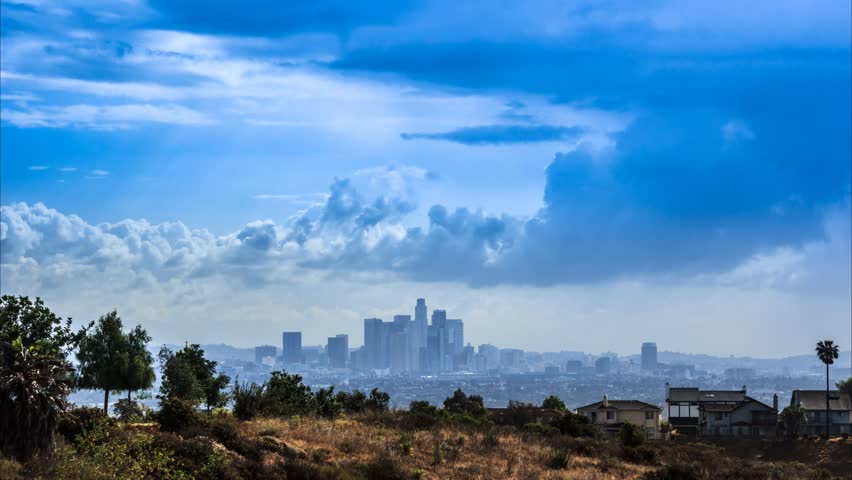 Beautiful white clouds moving over Los Angeles city skyline. Timelapse.