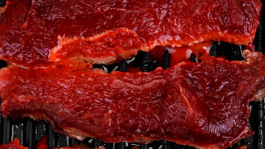 fresh raw bloody beef steaks on black grill plate 1920x1080 intro motion slow hidef hd