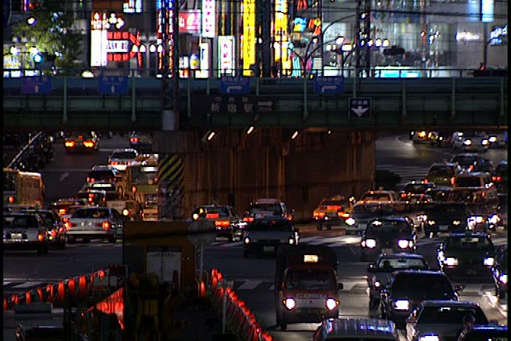 TOKYO - DECEMBER 06, 1996: WS multiple levels of night time traffic in underpass with subway train passing overhead. 