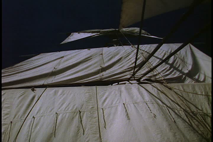 Historical reenactment of HMS Bounty ship on Rhode Island. Low angle shot of sails on main mast billowing in the breeze against a very dark sky.