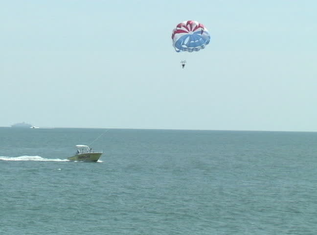 Parasailing in distance toward camera