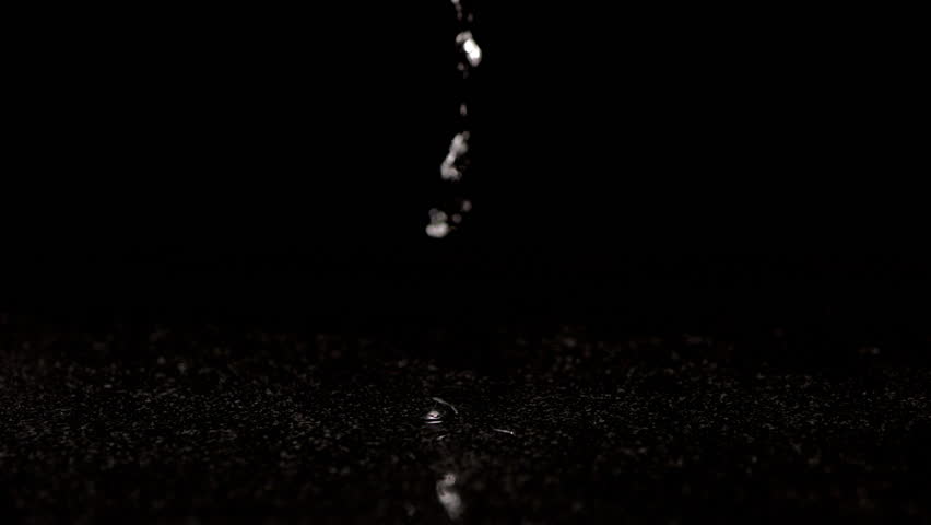 Fresh green chilli peppers falling in slow motion and drenched in water. On a black background.