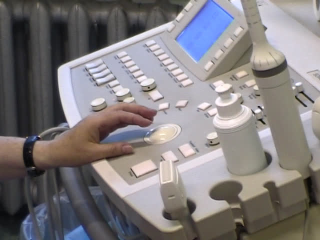 The doctor works on the keyboard of the ultrasonic device