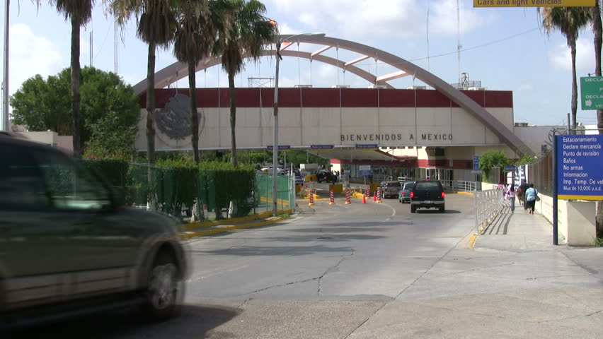 Video of border station USA and Mexico. Brownsville TX and Matamoros. Arch bridge over Rio Grande river. Vehicles and walker crossing bridge. Palm trees in tropical. Don Despain of Rekindle Photo