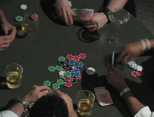 Four guys playing a poker game and drinking alcohol.