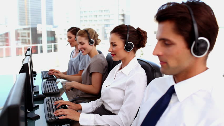 Smiling business people with headsets working in a call centre