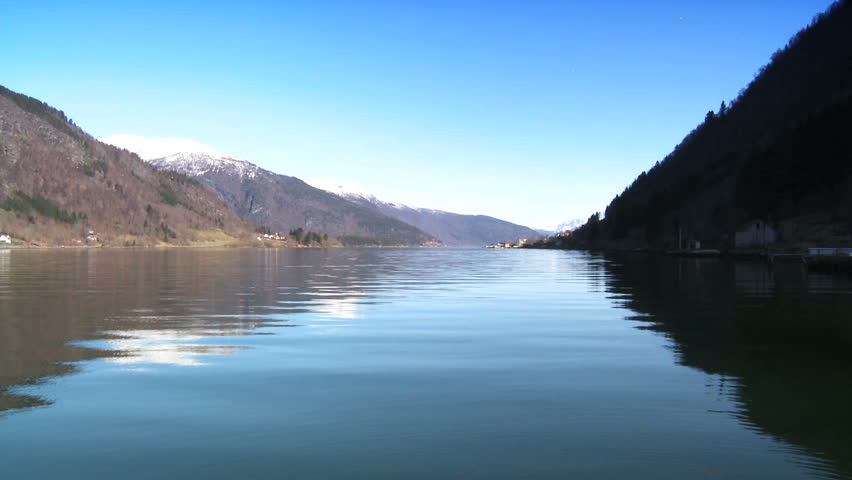 Wooden dwellings beside crystal waters of a glacial nordic fjord