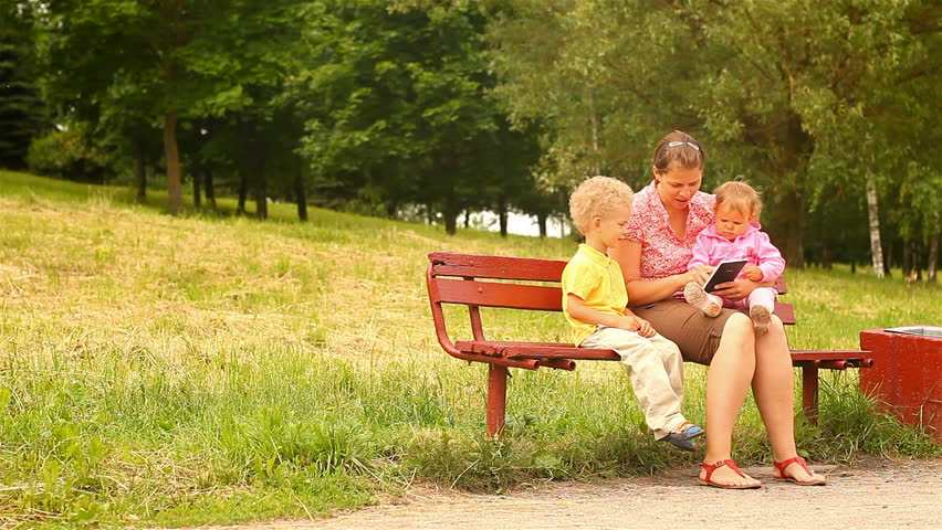 mother and two children, reading and watching Tablet Computers