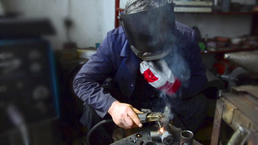 Industrial worker welding, Welder uses torch to make sparks during manufacture of metal equipment. LOOP